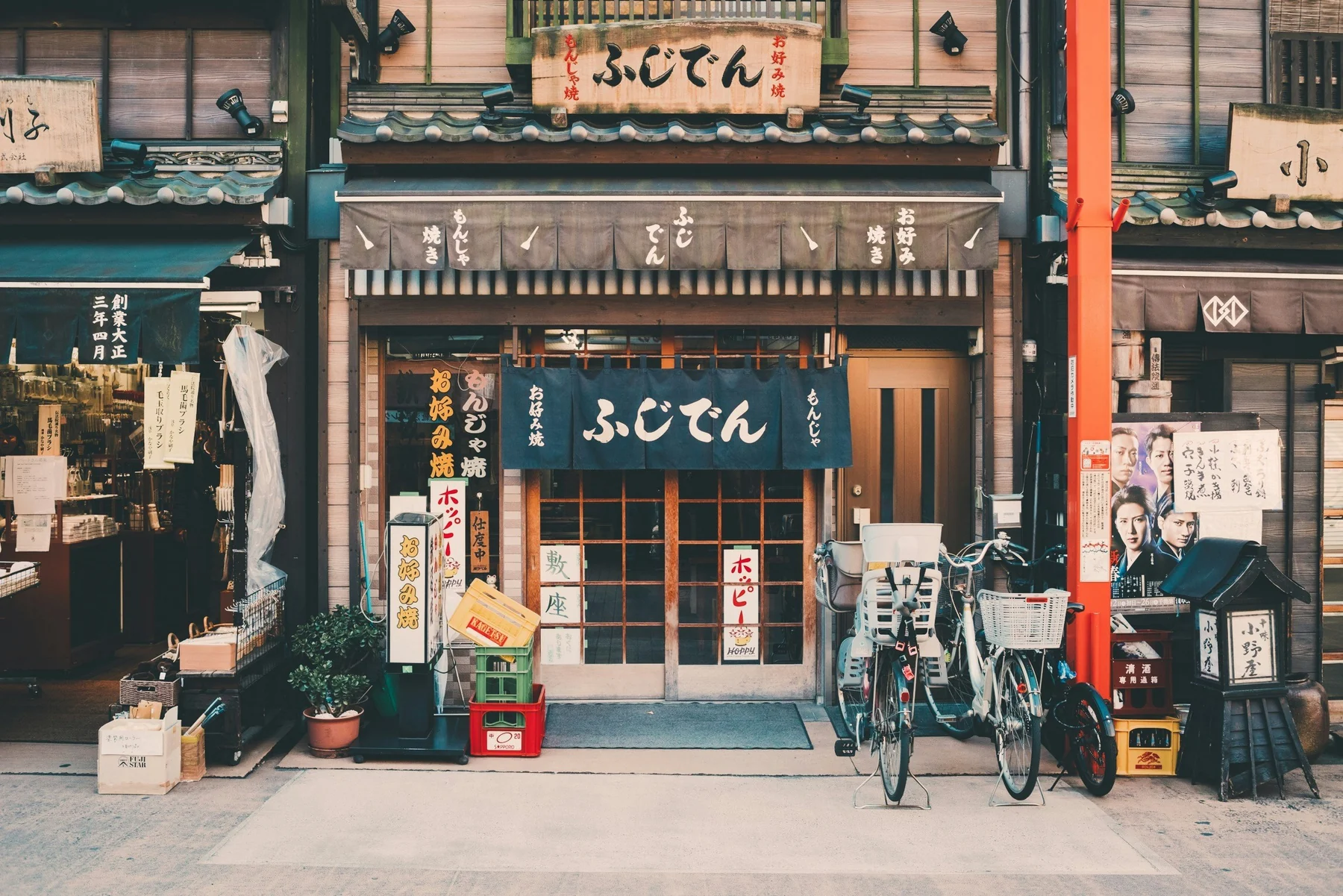 Original text-heavy source image for Japanese storefront - shop signage softened across a busy facade